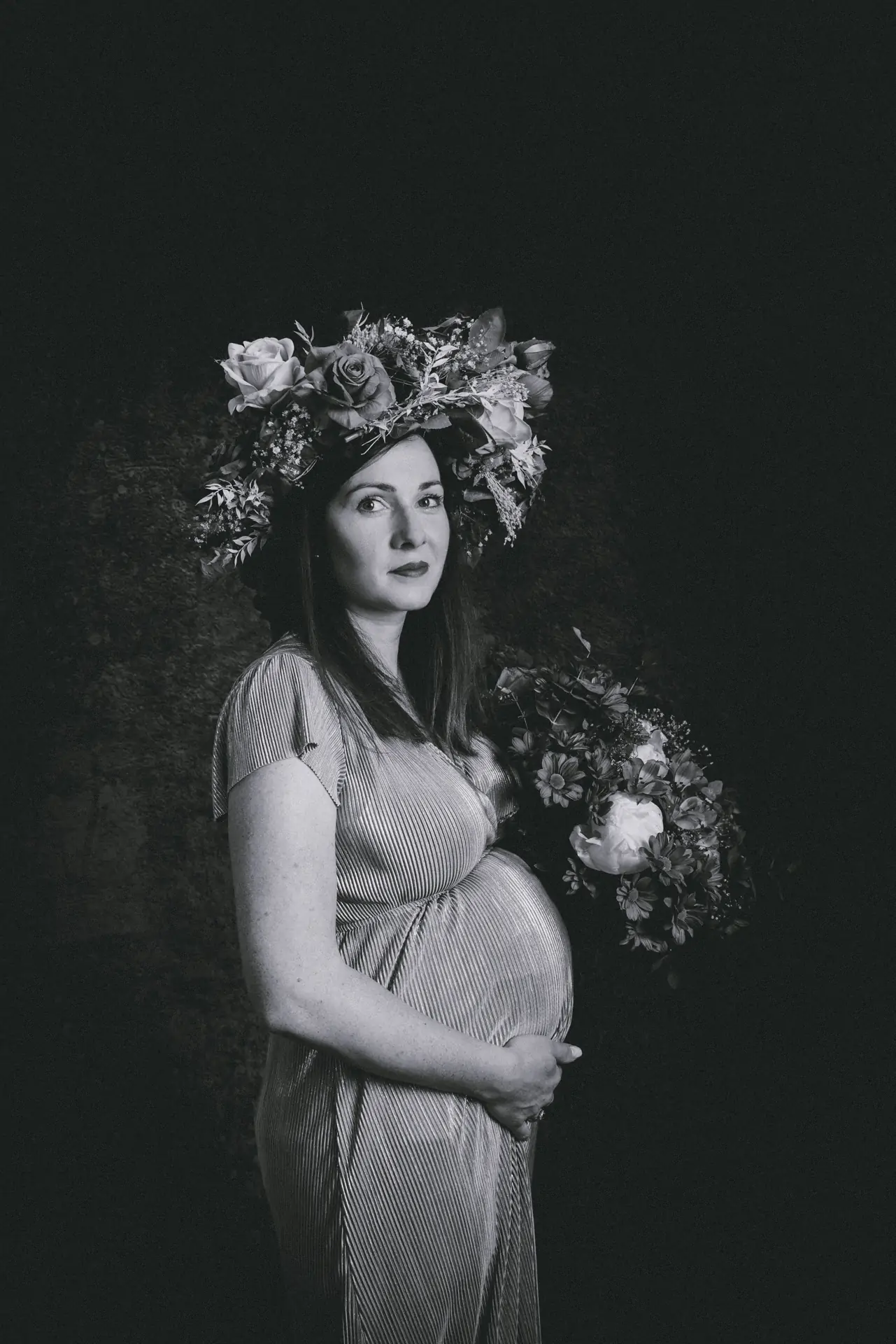 Portrait noir et blanc d'une femme enceinte dans un studio photo