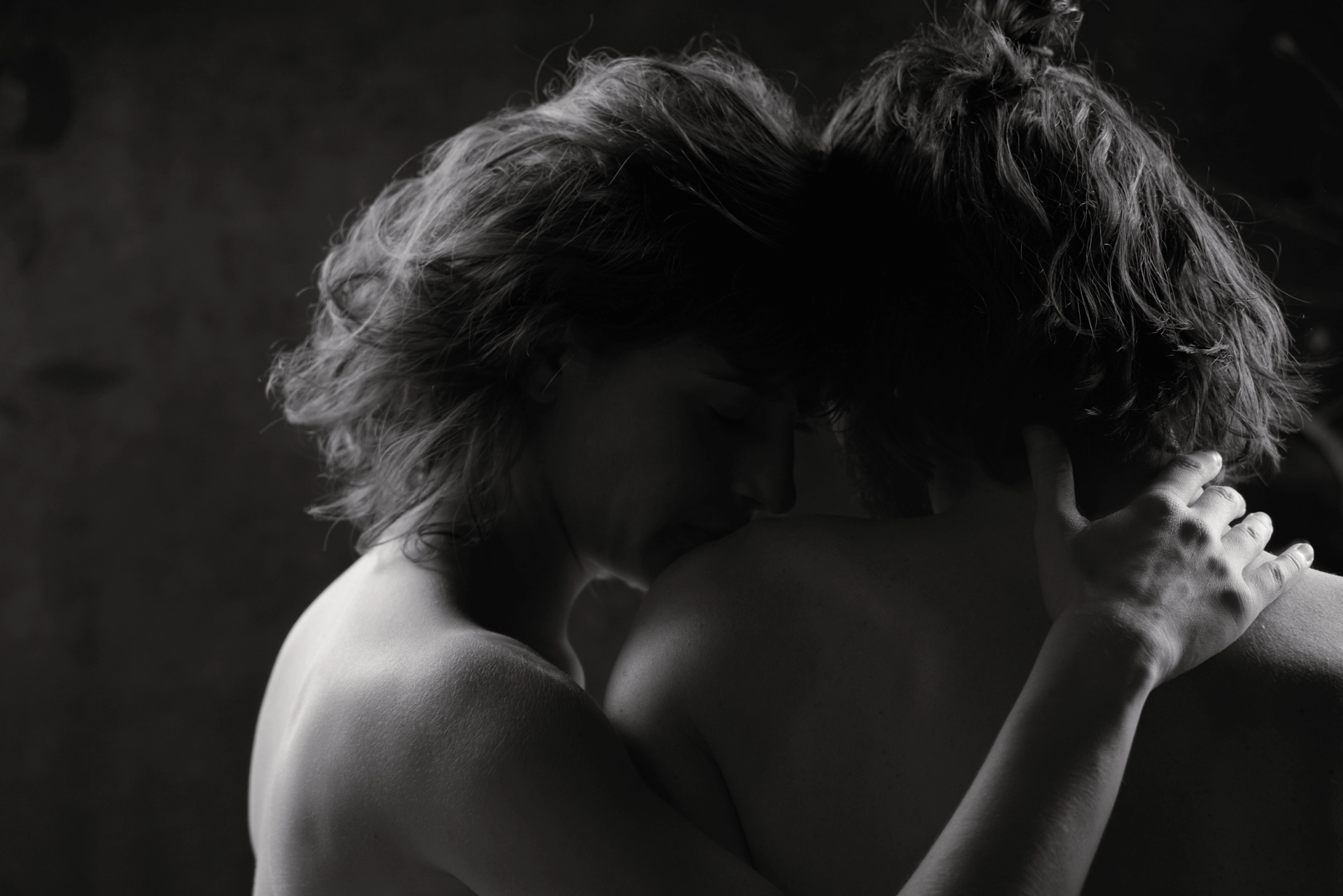 couple de dos nu très peu éclairé par la gauche en studio de photographie