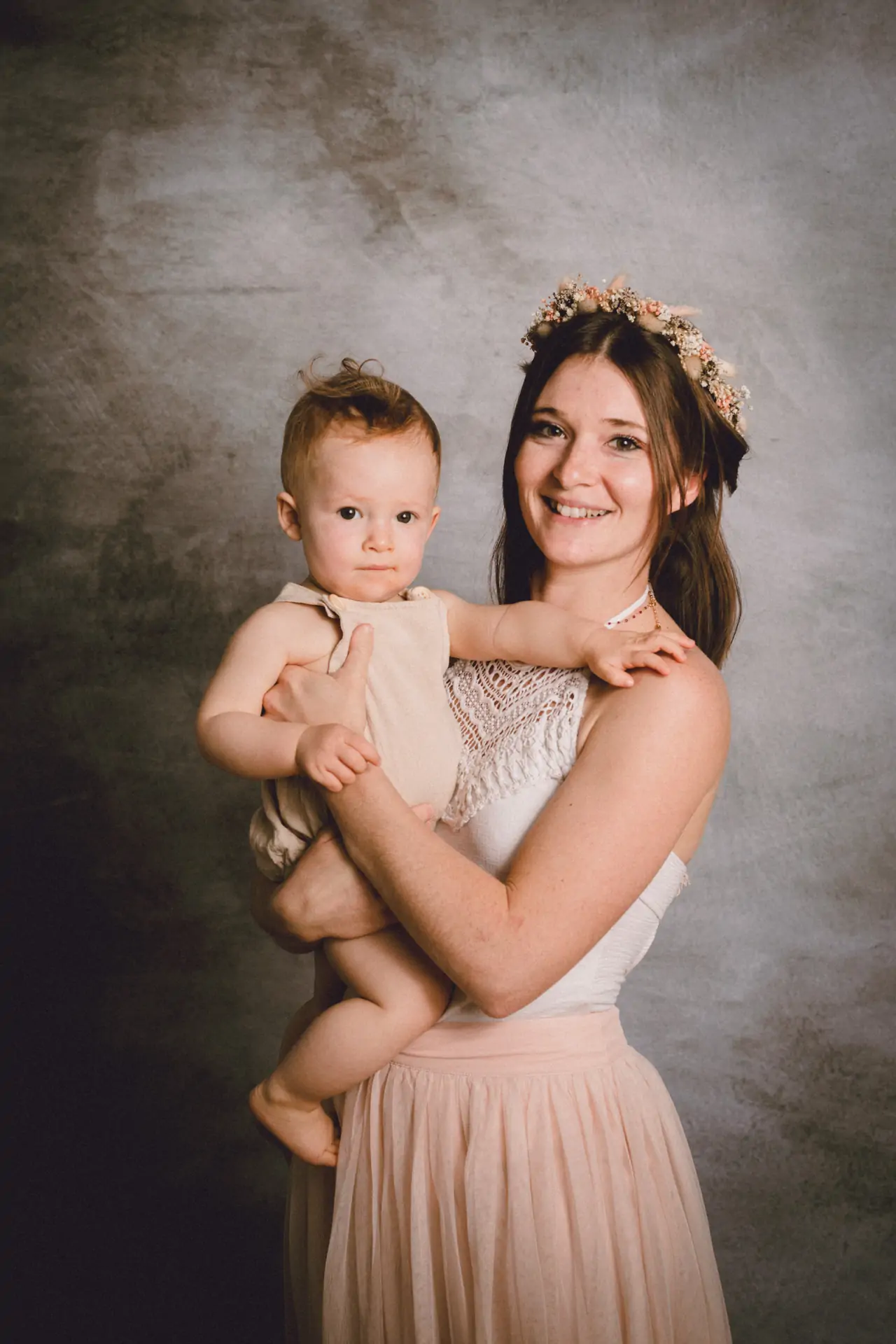jeune maman et son bébé de dix mois dans les bras ils regardent tous les deux l'objectif