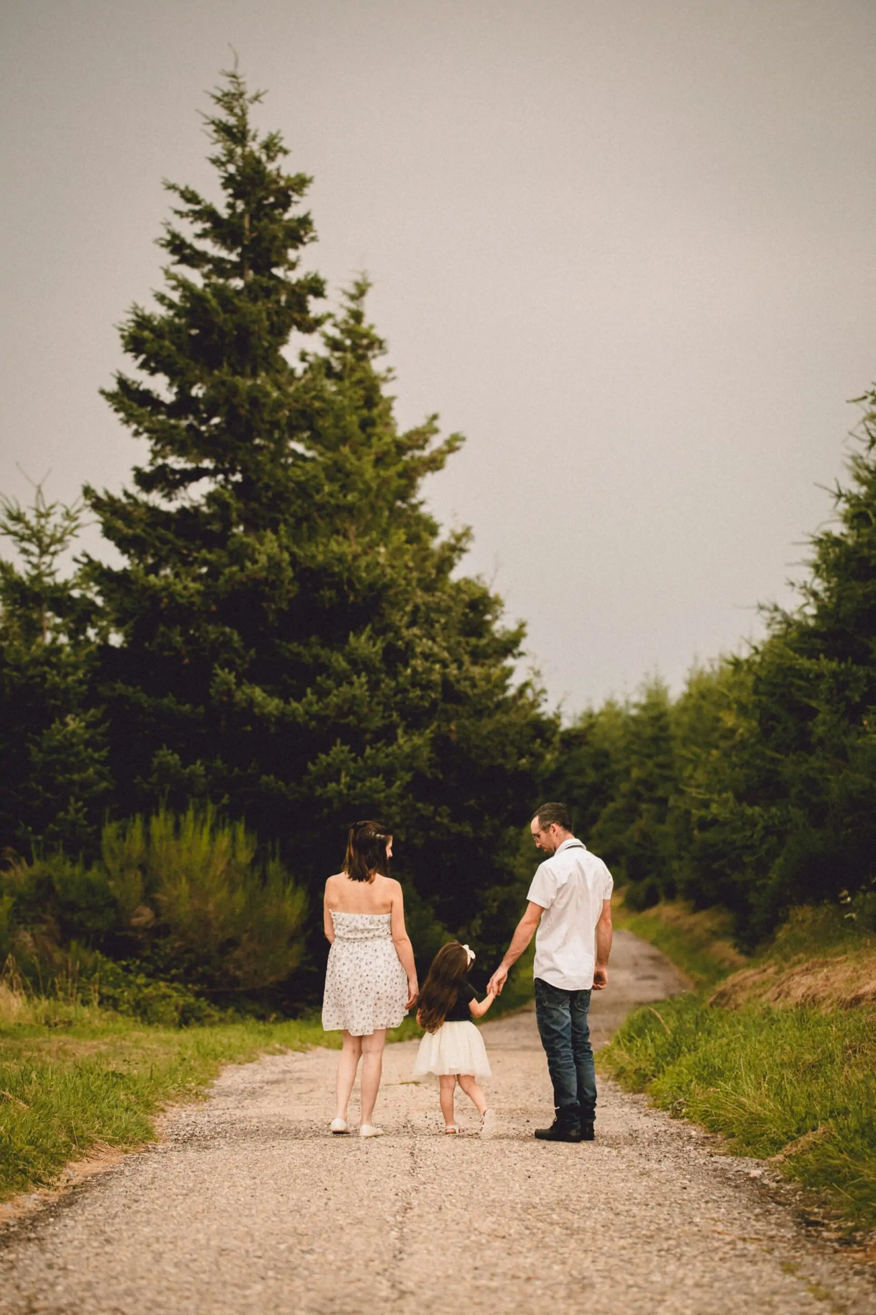 famille femme enceinte sur un chemin main dans la main avec une robe à fleurs