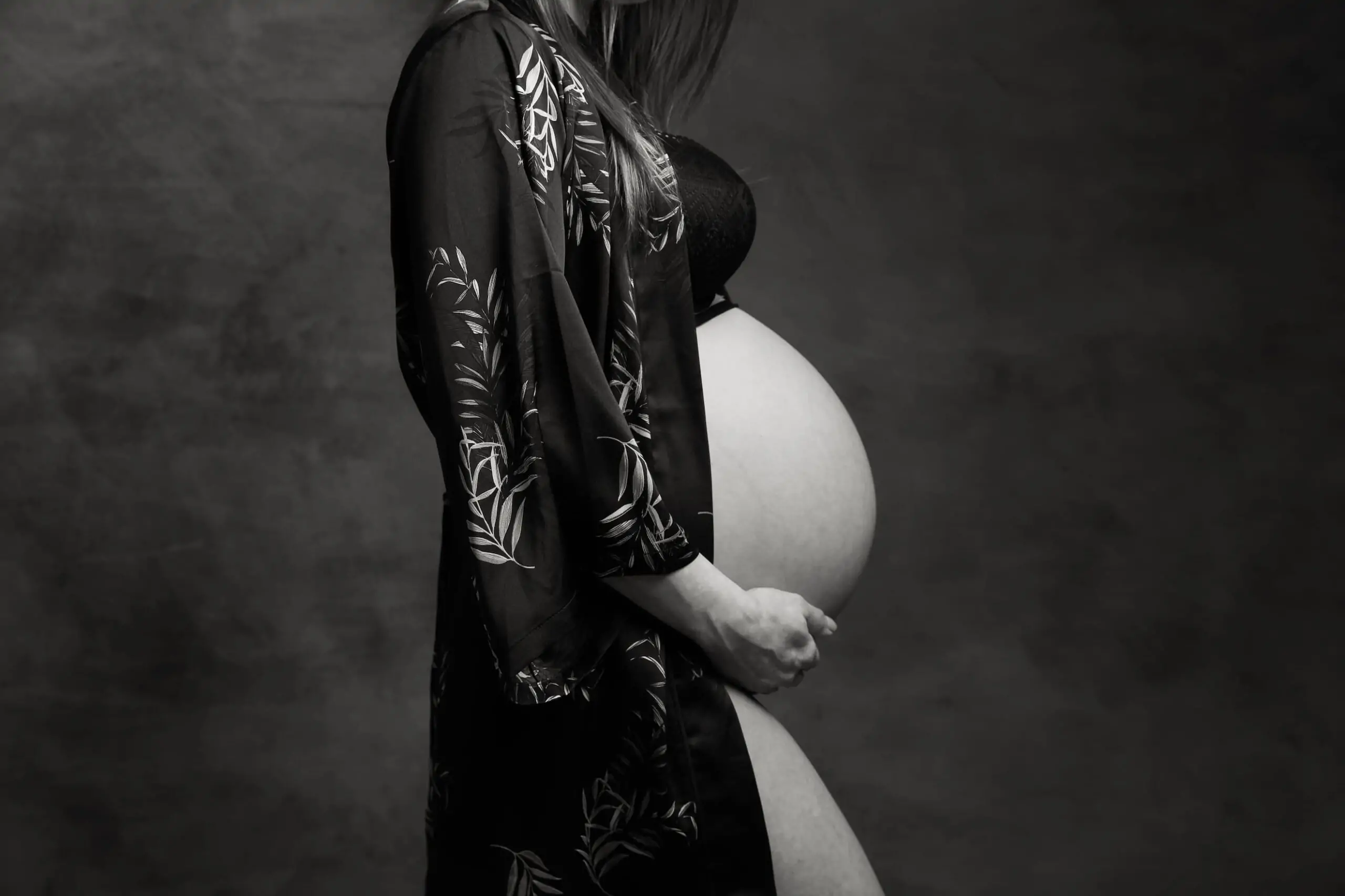 ventre femme enceinte en studio photo avec un peignoir en soie vert