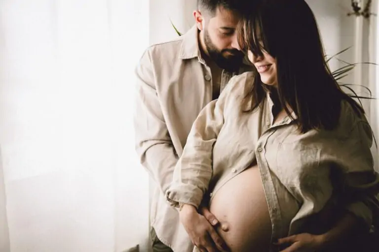 couple qui attend un bébé devant une fenêtre