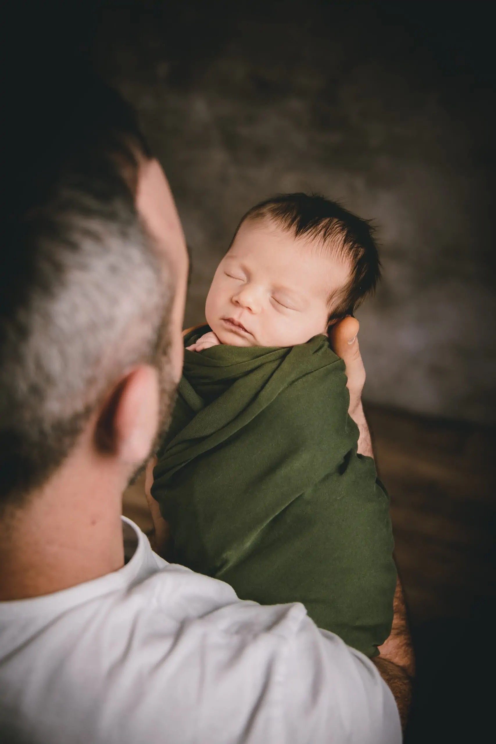 papa qui tient son bébé tout petit dans ses bras