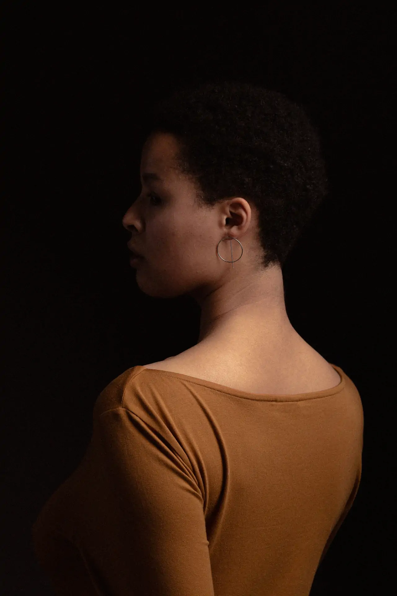 portrait photo d'une femme métisse de profil et en couleur prise en studio photo