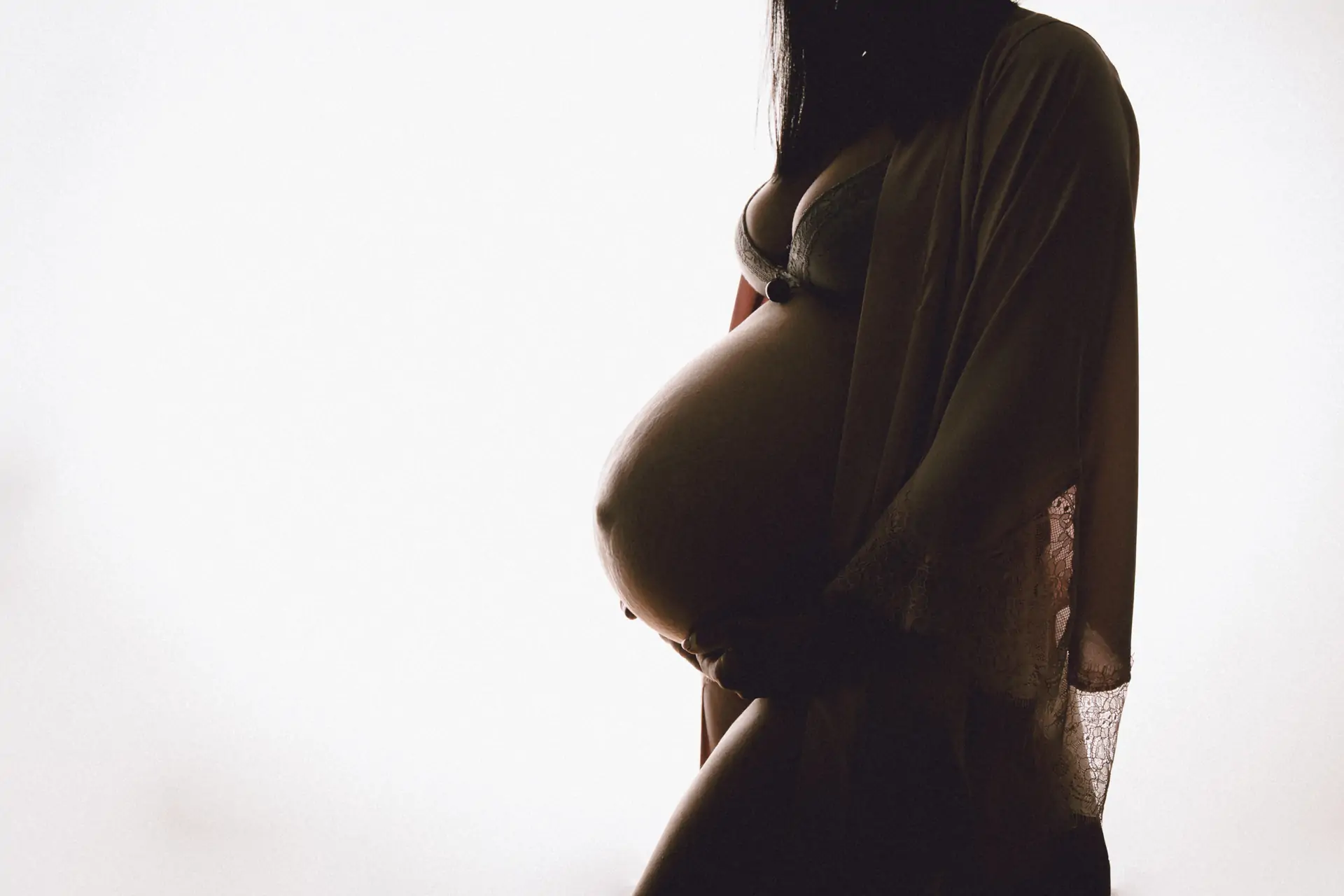 Photo d'une femme enceinte avec contre jour dans un studio photographique